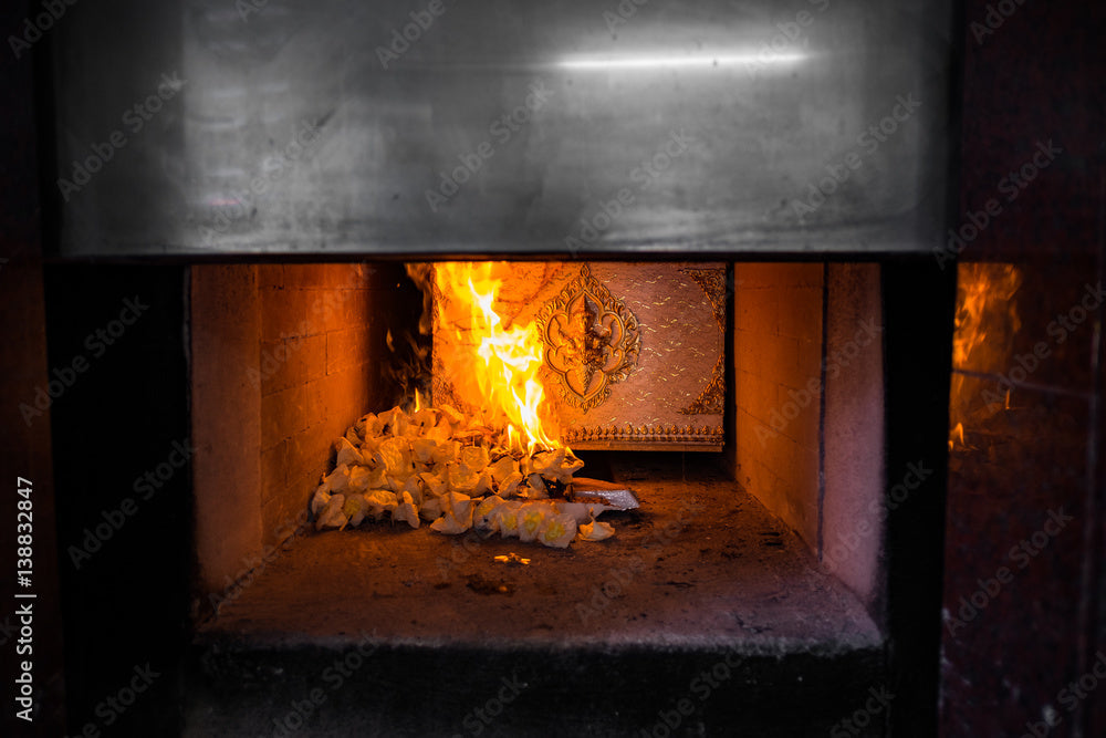 Ornate cremation casket in a crematorium chamber with flames, solemn farewell setting
