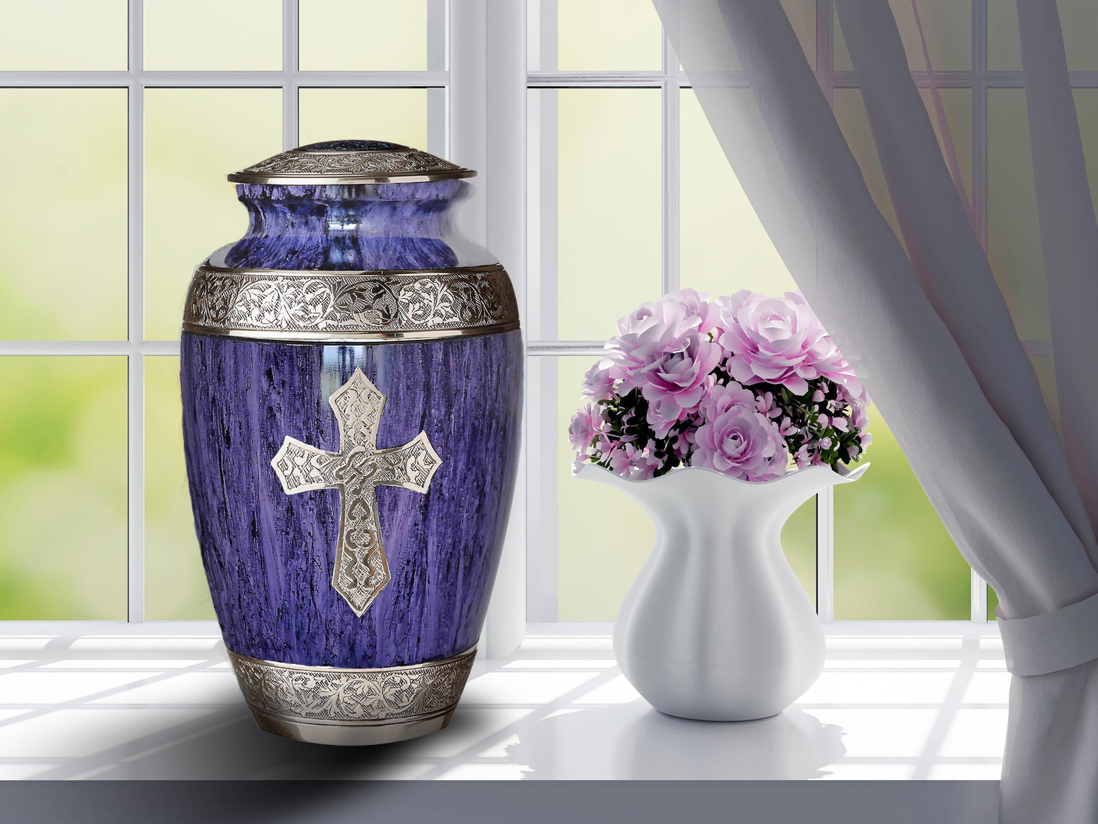 Purple metal cremation urn with silver cross and ornate trim beside vase of pink roses on windowsill