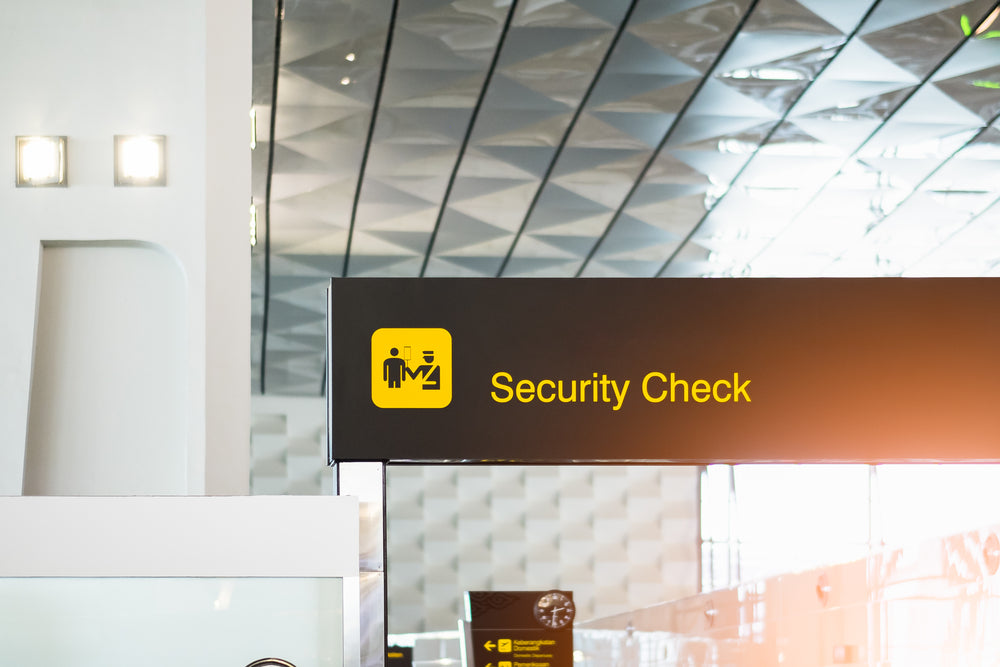 Airport security check sign with modern ceiling and yellow icon visible